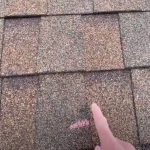 Downey Roofing worker marking roof from damage